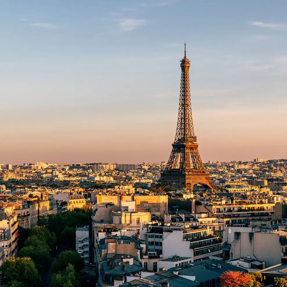 Eiffeltårnet og Paris' bylandskap i varmt kveldslys.