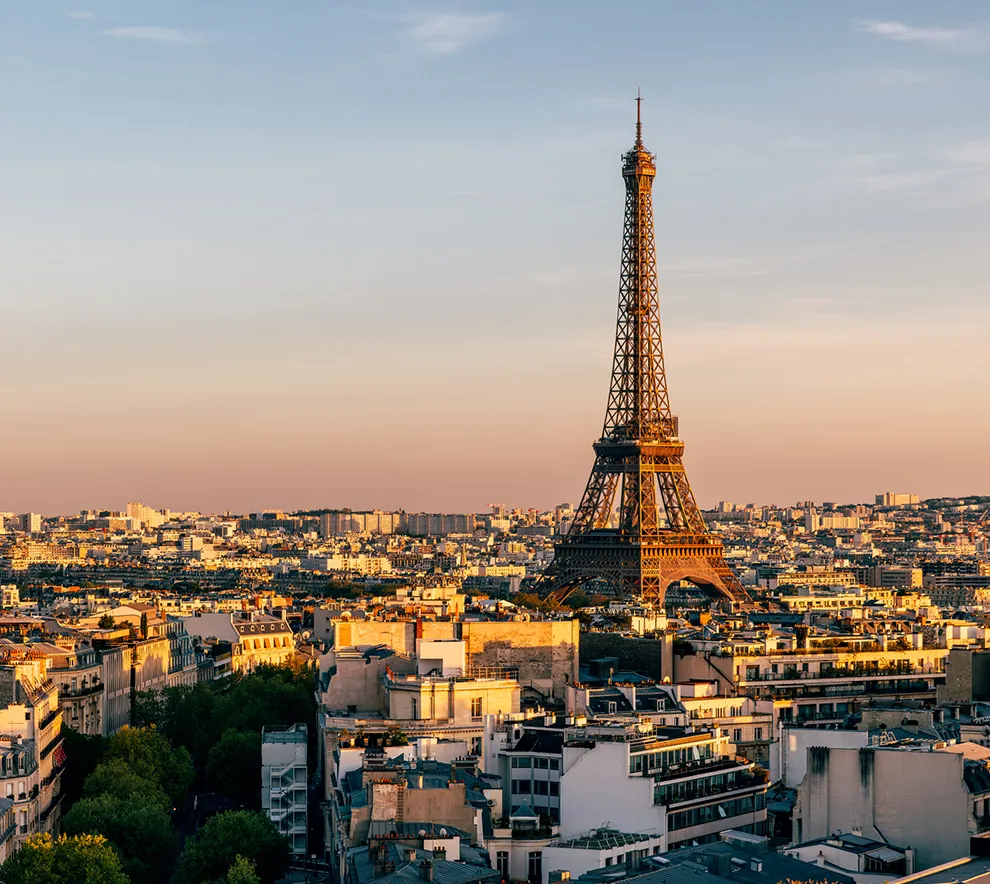 Eiffeltårnet og Paris' bylandskap i varmt kveldslys.
