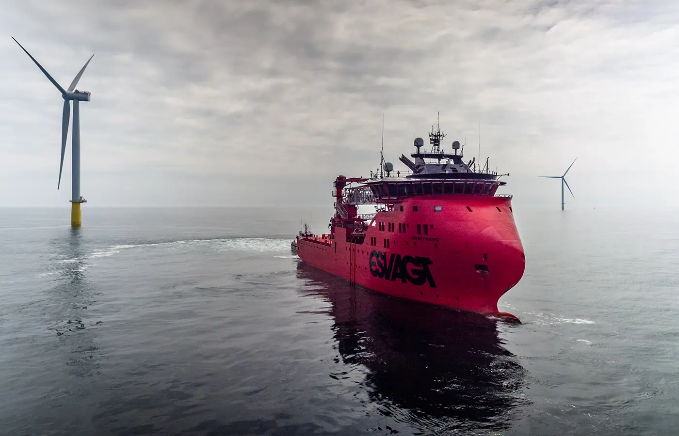 ESVAGT-servicefartøy opererer ved offshore vindturbiner i havvindpark – maritim støtte for fornybar energi.