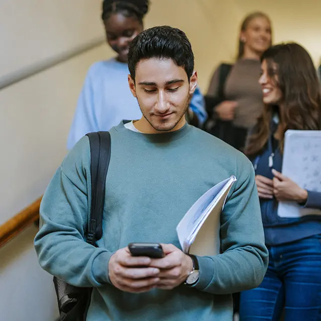 Fires studenter går ned trapp, skolenotater i hendene smiler, 