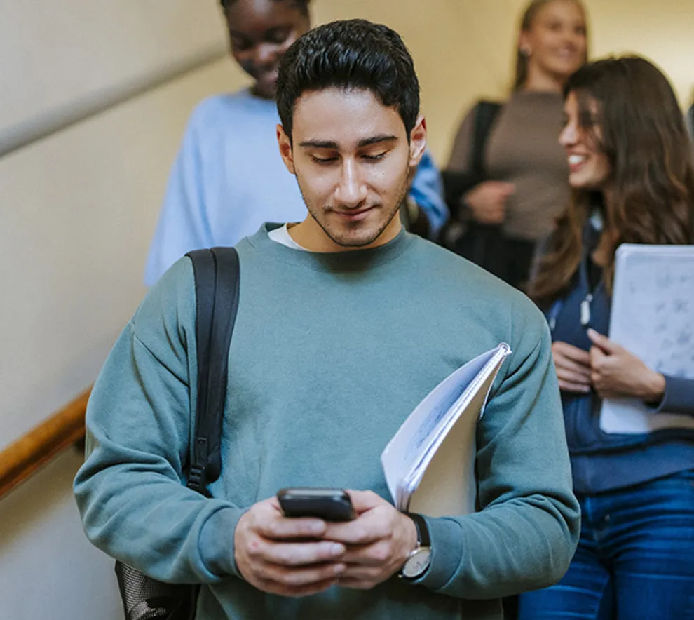 Fires studenter går ned trapp, skolenotater i hendene smiler,