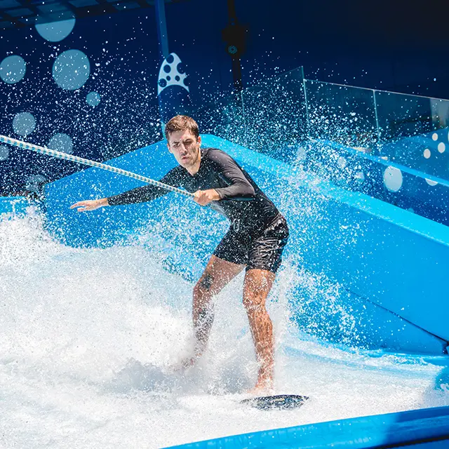 Mann står på surfebrett på en surfebølgemaskin