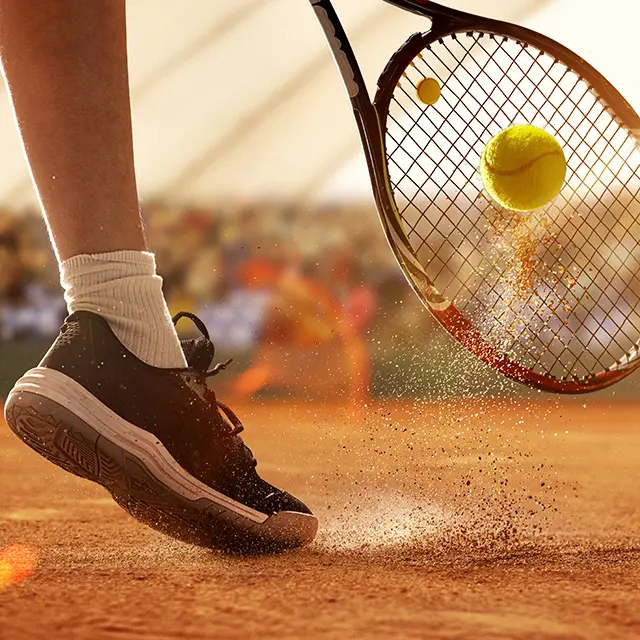 Nærbilde av tennisracket og sko på bane