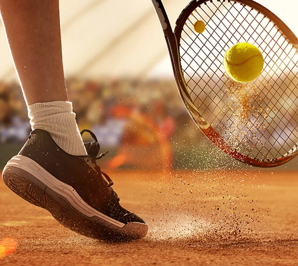Nærbilde av tennisracket og sko på bane