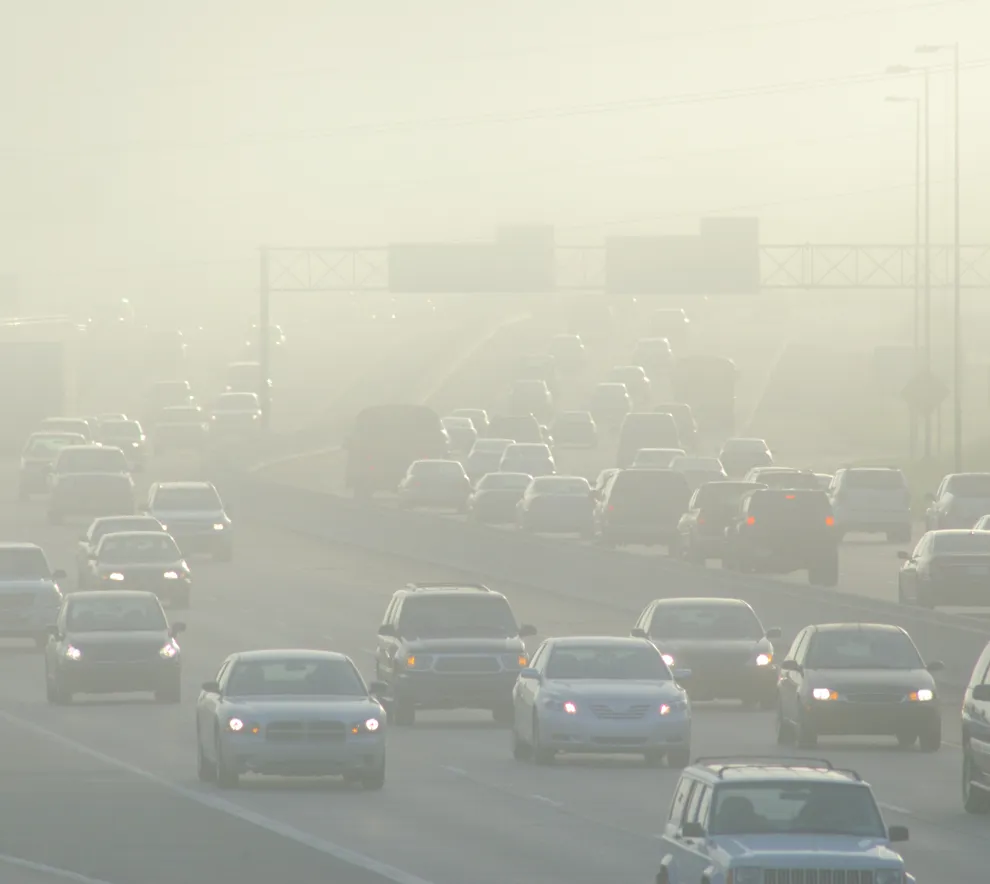 Rushtrafikk kjører gjennom forurenset luft.