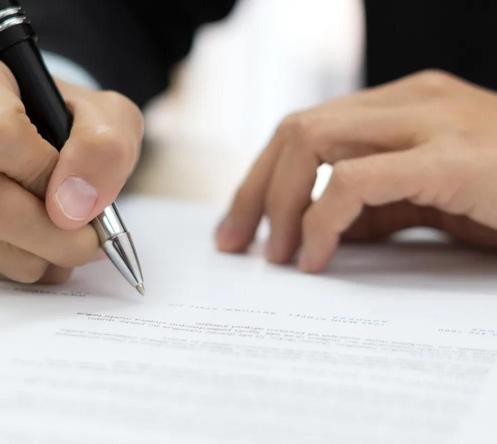 Person skriver under på avtale eller protokoll