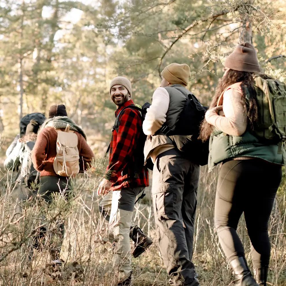 Venner på tur sammen i skogen med ryggsekker.