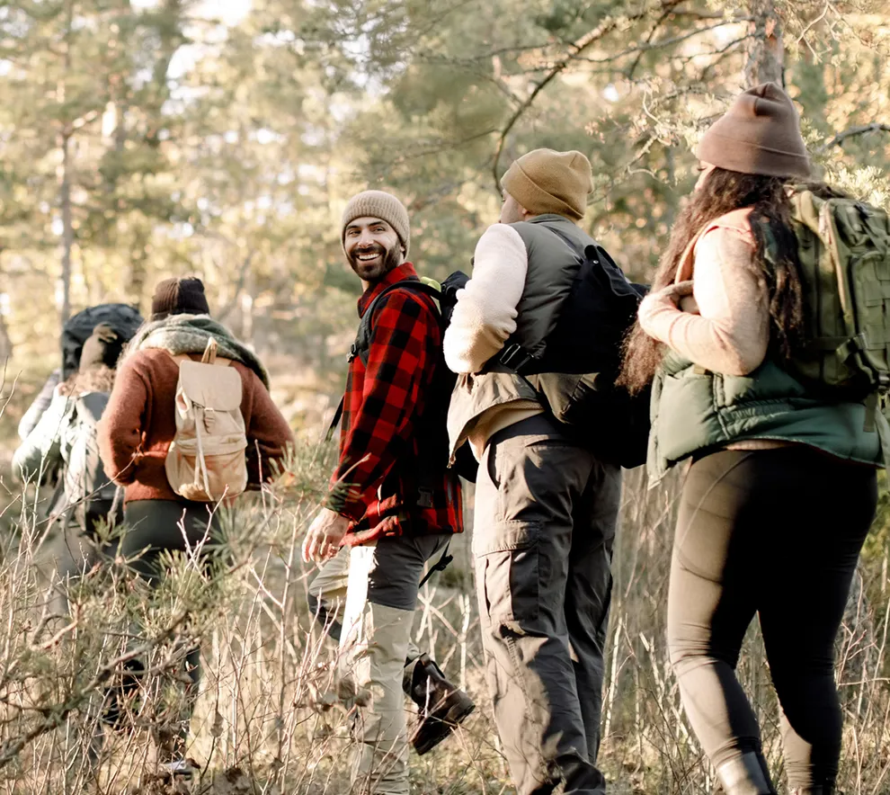 Venner på tur sammen i skogen med ryggsekker.