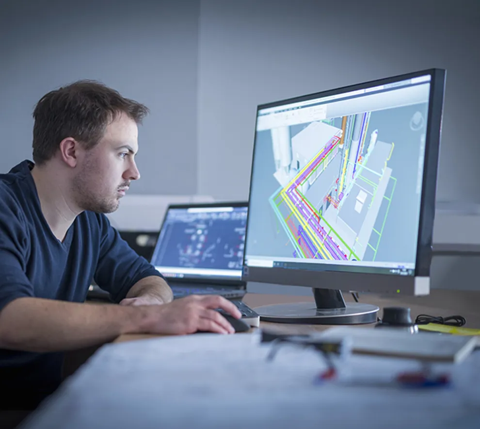 En mann jobber med en digital tegning av et byggeprosjekt.