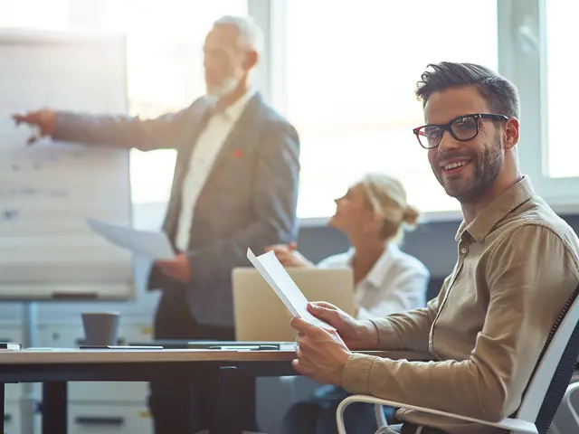 Mann ser på et foredrag med kollegaer