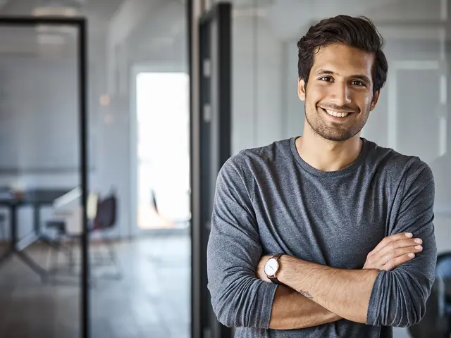 Mann som står med armene i kors