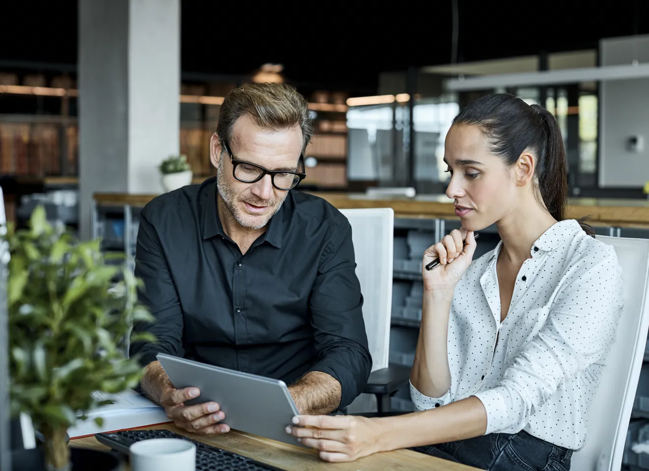To kollegaer som samarbeider og ser på samme skjerm.