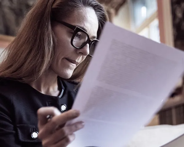Kvinne leser over noen dokumenter