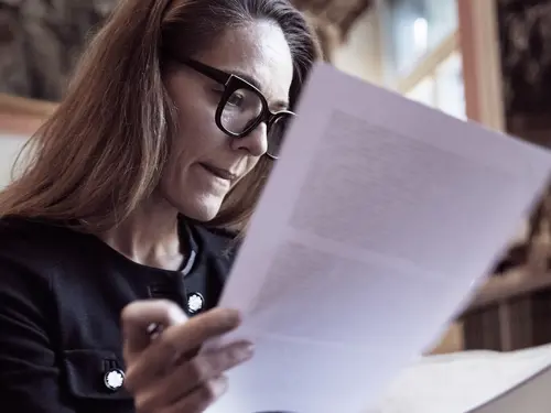 Kvinne leser over noen dokumenter