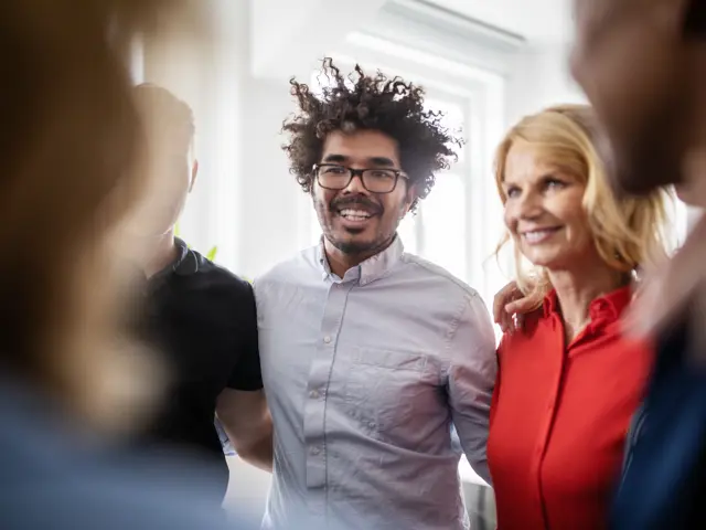 Kolleger som holder rundt hverandre - samarbeid