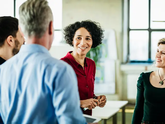En gruppe kollegaer som ler og snakker sammen