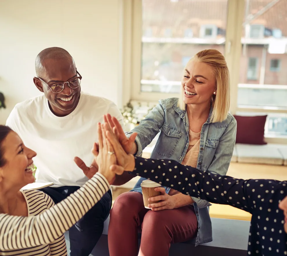 Fire personer gir hverandre en samlet high five