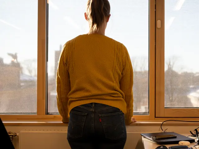 Person som står foran vindu med ryggen til