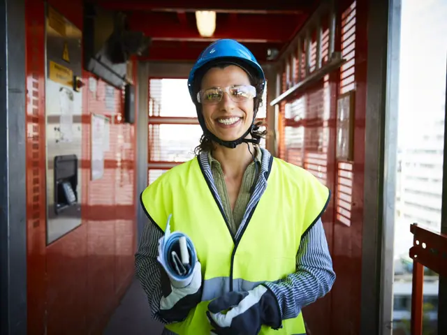 En ung kvinne i verneutstyr som smiler til kamera