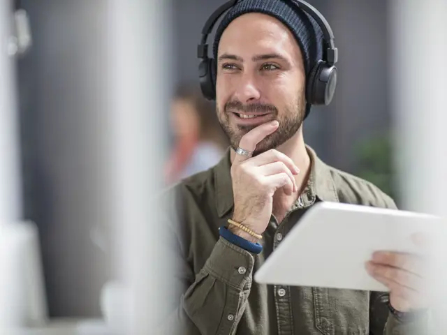 Illustrasjonsbilde av en ung mann med nettbrett og headset