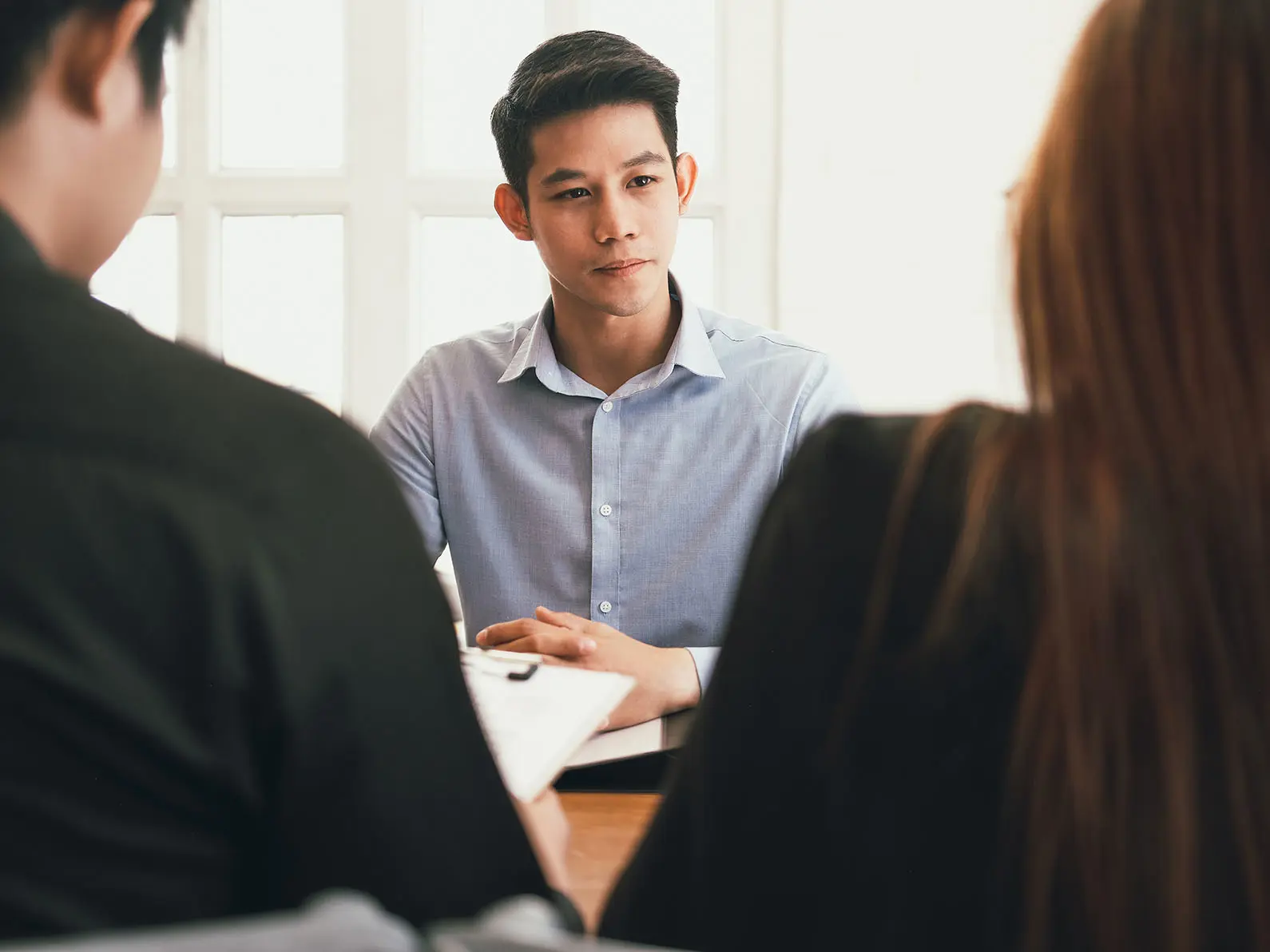 Illustrasjonsbilde av en ung mann på jobbintervju hos en mann og en kvinne