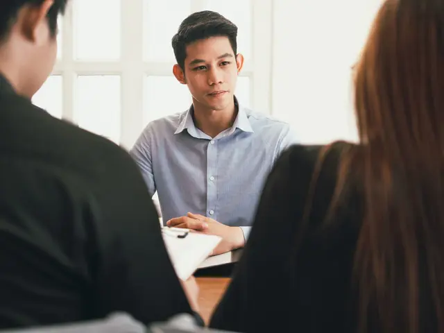 Illustrasjonsbilde av en ung mann på jobbintervju hos en mann og en kvinne