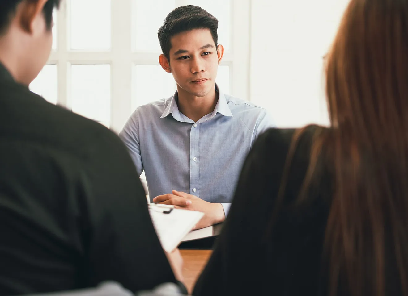 Illustrasjonsbilde av en ung mann på jobbintervju hos en mann og en kvinne