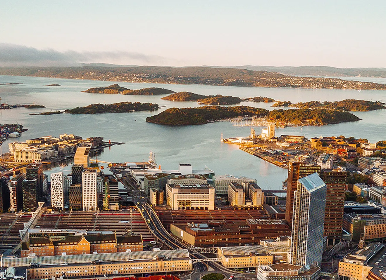 Flyfoto av Oslo sentrum med byen nærmest og fjorden med øyene i bakgrunn