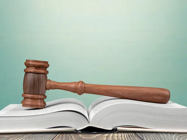 Illustrasjonsbilde av en hammer på en bok med låver