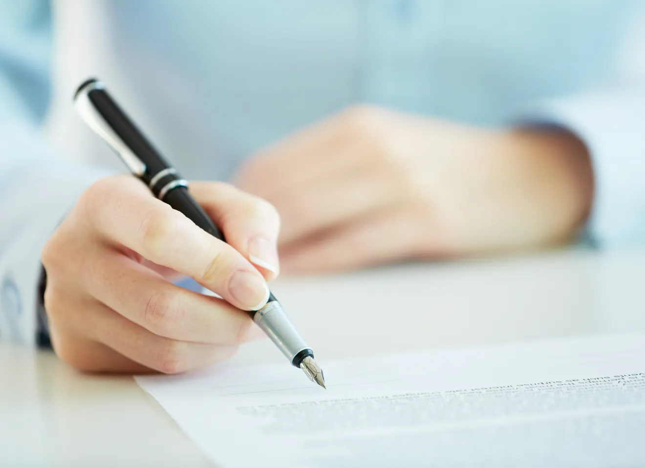 Illustrasjonsbilde av en hånd som holder en pen for å signere på en kontrakt