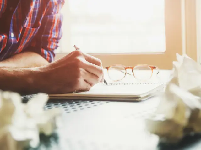 Illustrasjonsbilde av hender med pen som skriver en søknad