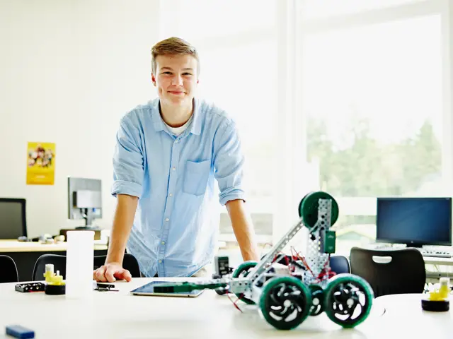 Ung mann med en robot 