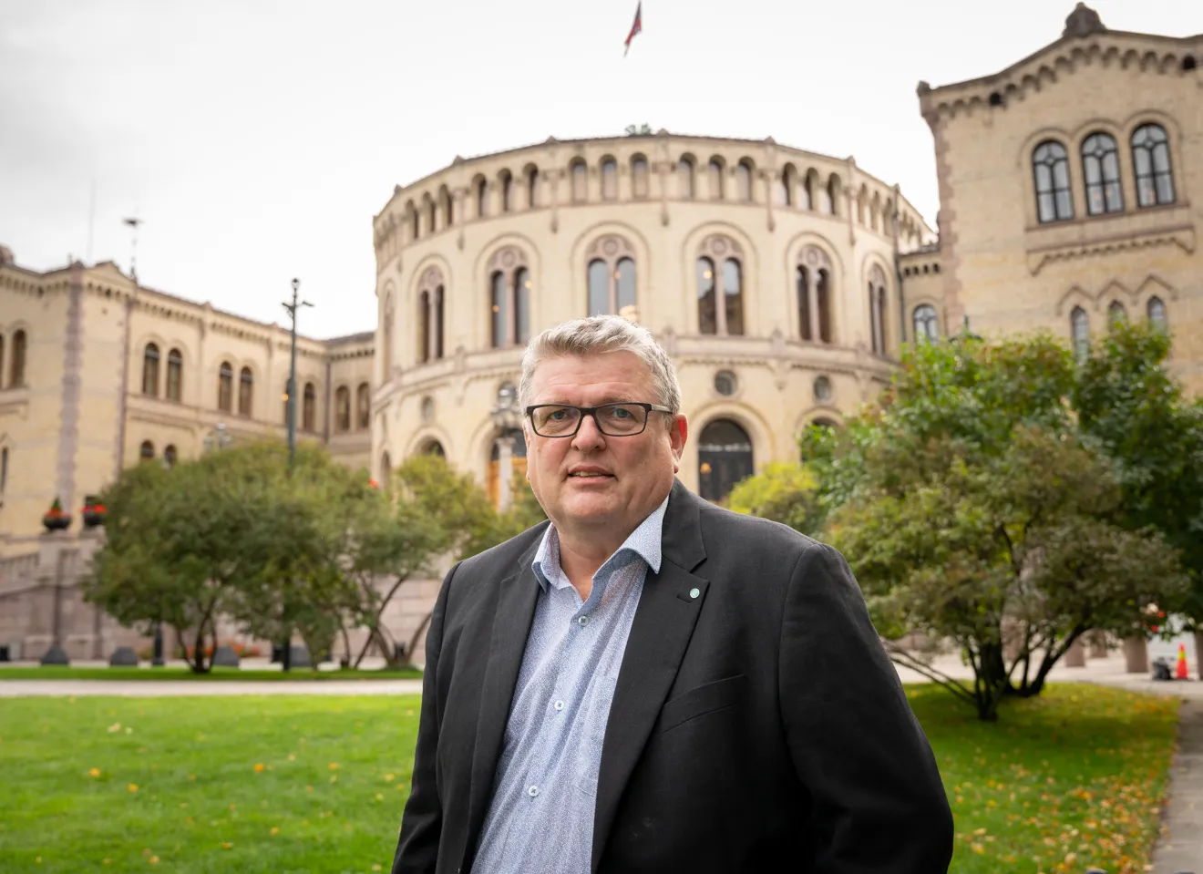Lars Olav Grøvik foran Stortinget med seriøs blikk