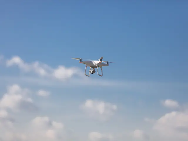 Drone foran blå himmel med hvite skyer